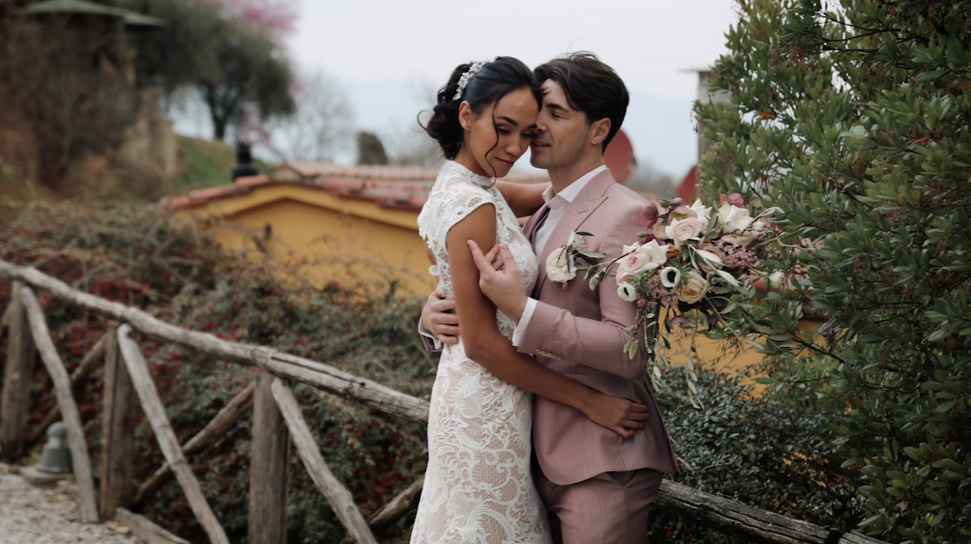 Bruidegom streelt bruid teder over arm op prachtige trouwlocatie in Toscane